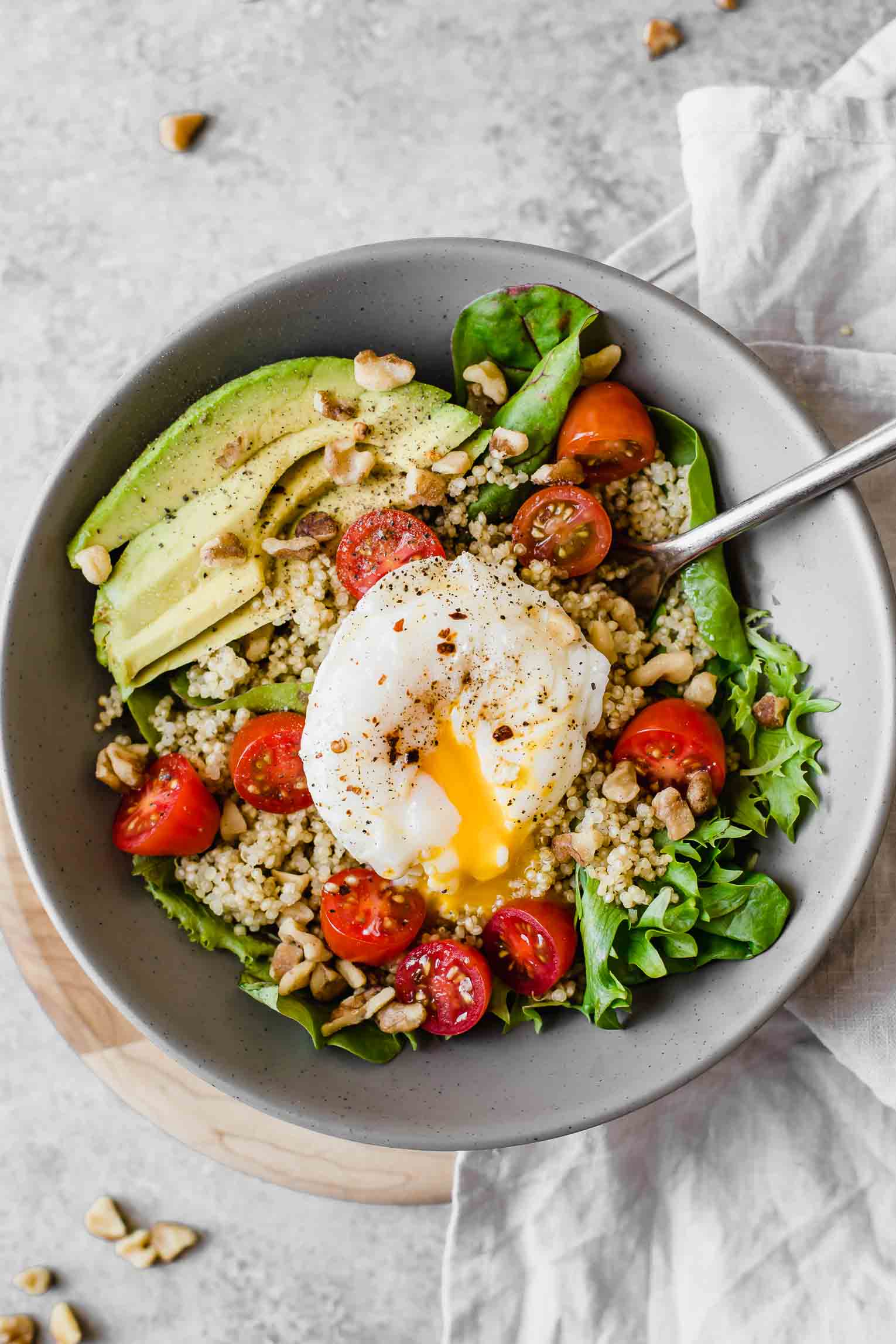 Close up of Poached Egg & Avocado Breakfast Salad in a grey bowl.