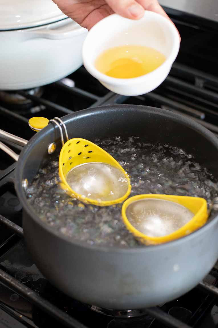Egg poachers in a pot of boiling water.