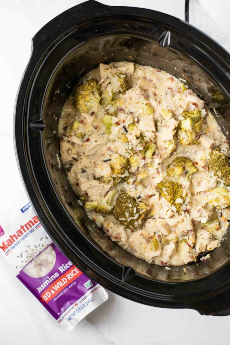 Top shot of Crockpot Chicken and Rice in slow cooker next to Mahatma Rice.