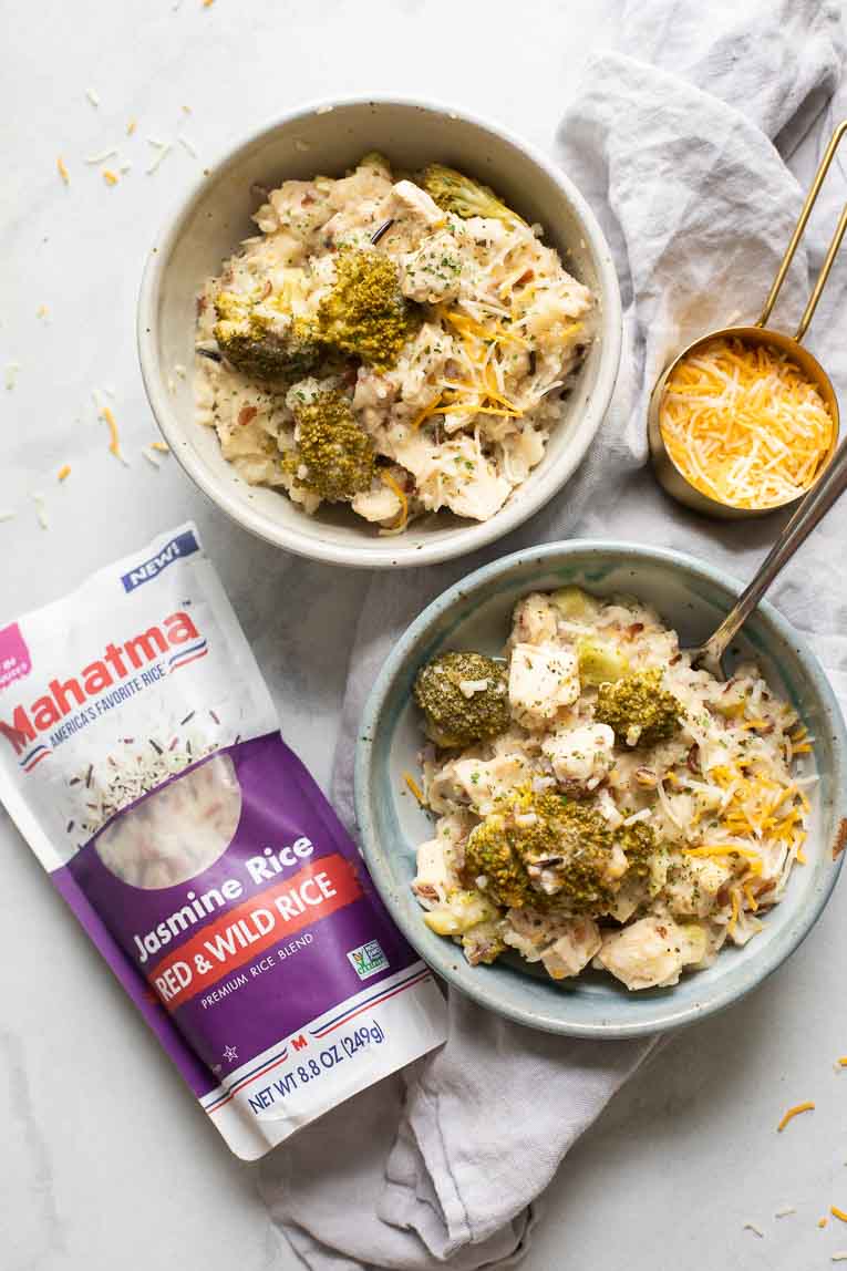 Crockpot Chicken and Rice in bowls next to Mahatma Rice and shredded cheese.
