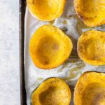 Roasted acorn squash on a baking sheet with parchment paper.