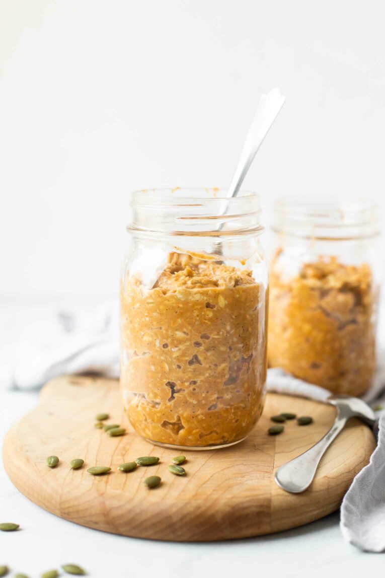 Pumpkin Pie Overnight Oats in a glass mason jar with a spoon.