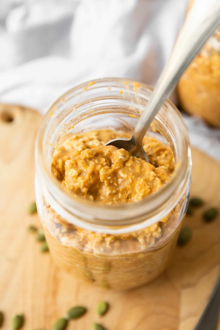 Top shot of pumpkin overnight oats in a mason jar with a spoon.