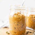 Close up of pumpkin overnight oats in a mason jar with a spoon.