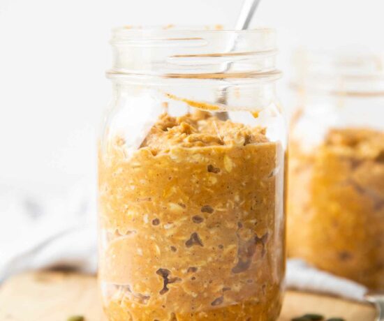 Close up of pumpkin overnight oats in a mason jar with a spoon.