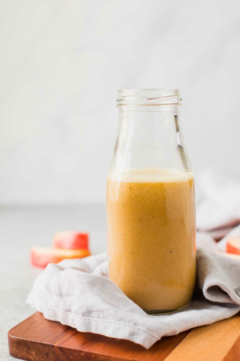 Close up of apple cider vinaigrette recipe in a glass bottle.