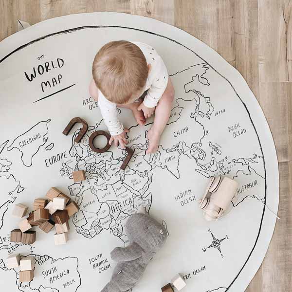 Top shot of baby playing on a Gathre world map.