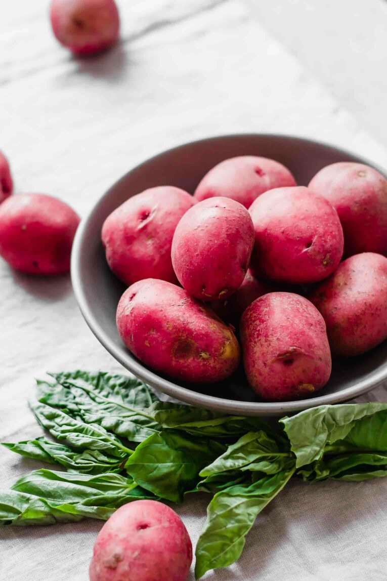 Dark bowl full of red potatoes.