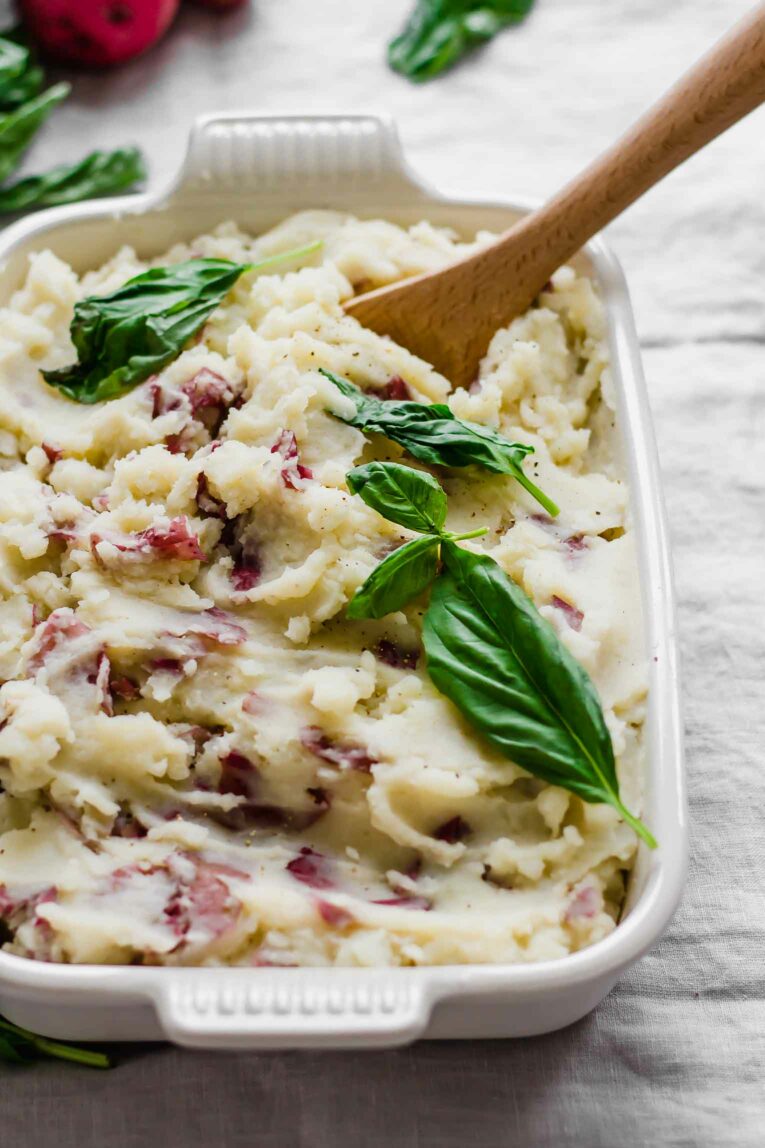 Close up of garlic mashed red potatoes in a serving dish.