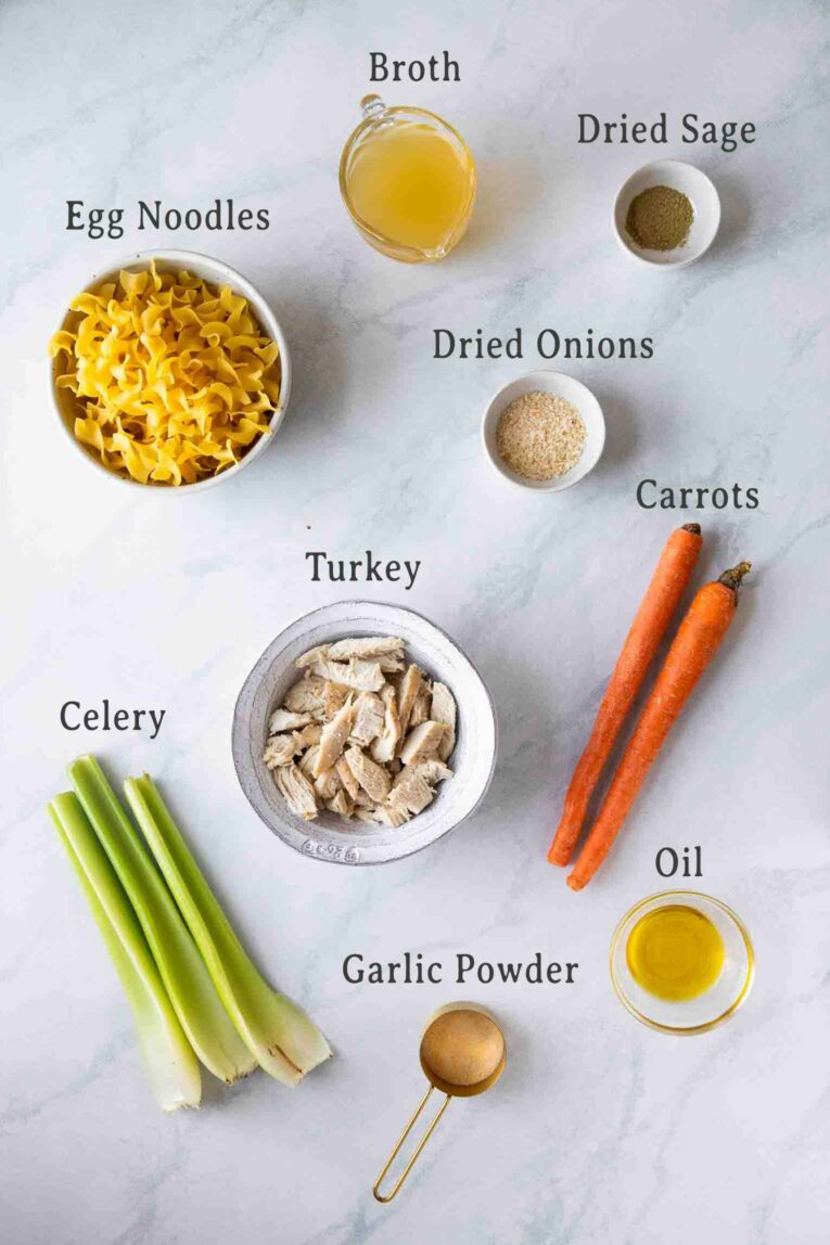 Ingredients for easy turkey noodle soup on a marble board.