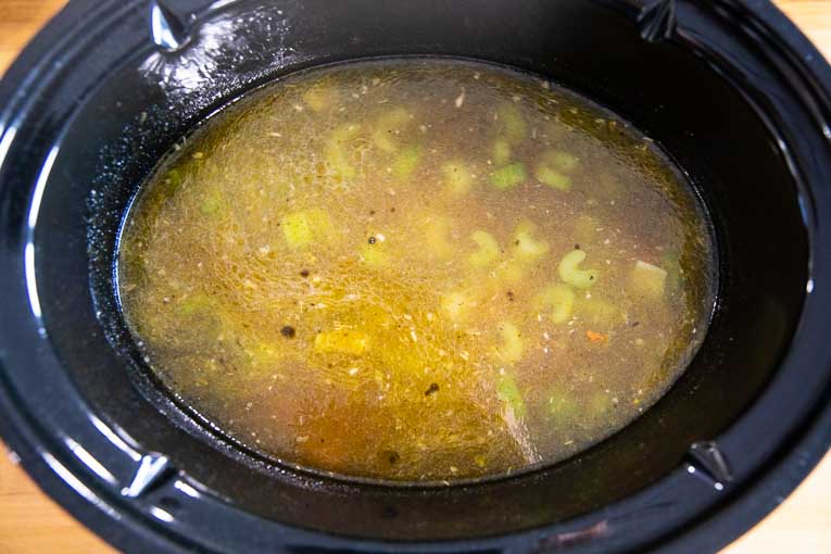 Broth and veggies in a slow cooker.