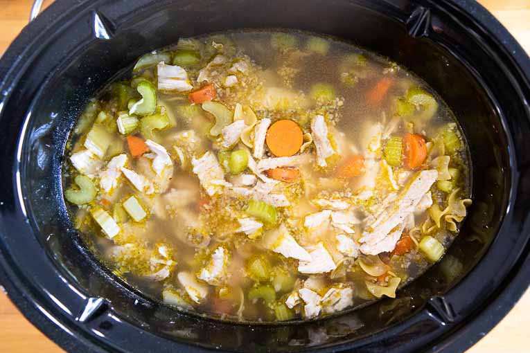 Turkey noodle soup ingredients in a slow cooker.