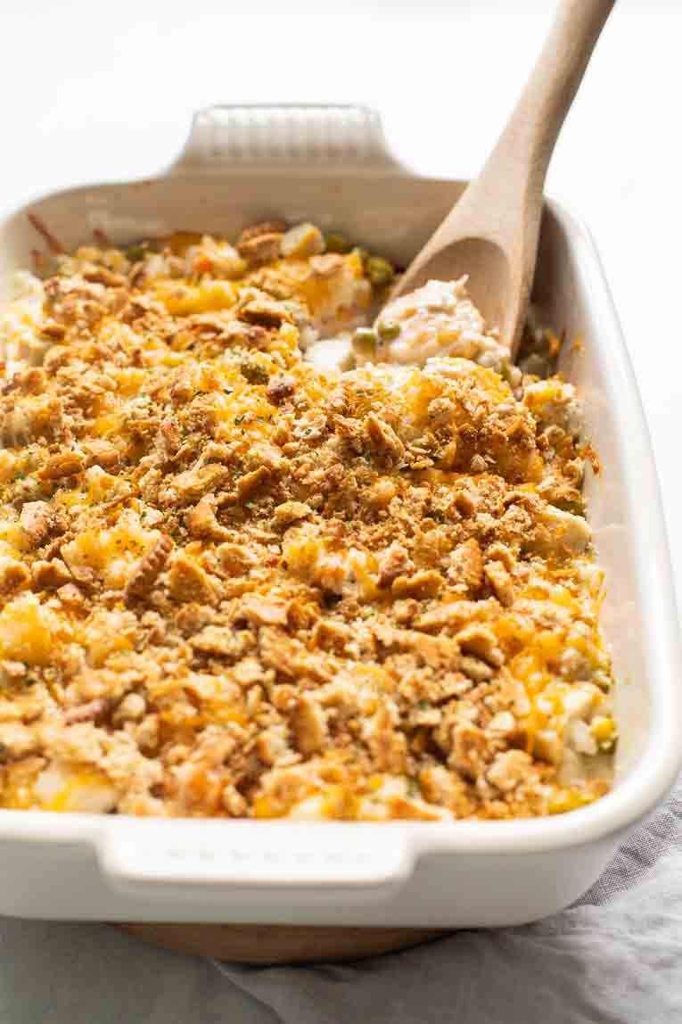 Across shot of Turkey Rice Casserole with a wooden spoon taking a scoop out.