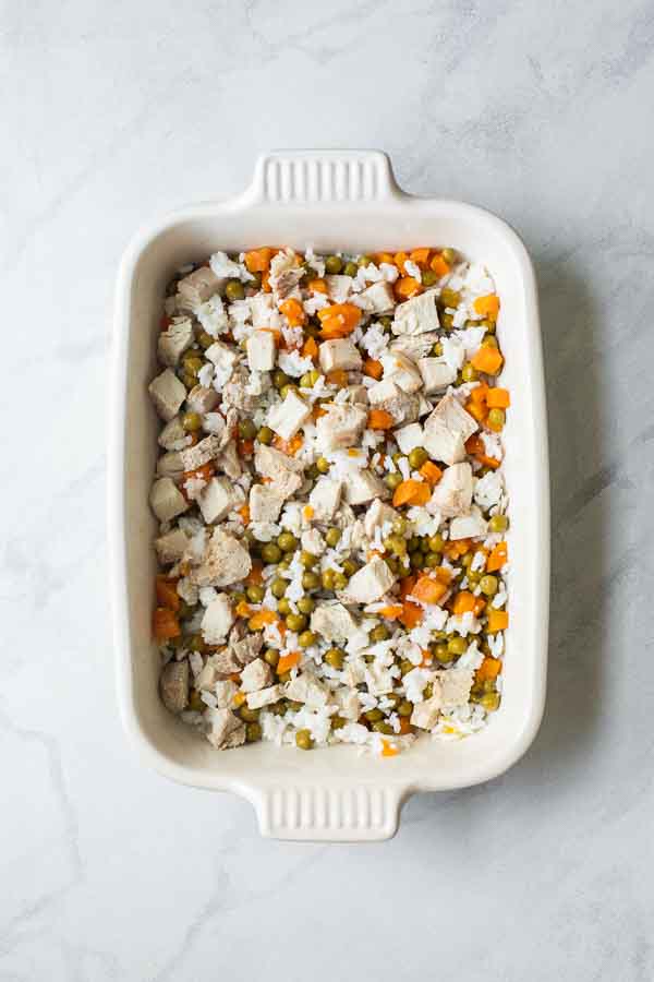 Rice, peas, carrots, and turkey in a casserole dish.