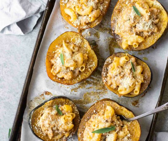 Mac and cheese stuffed acorn squash on a baking sheet.