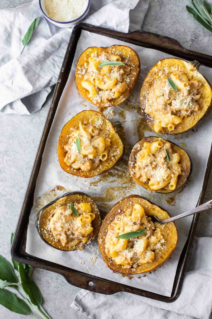 Mac and cheese stuffed acorn squash on a baking sheet.