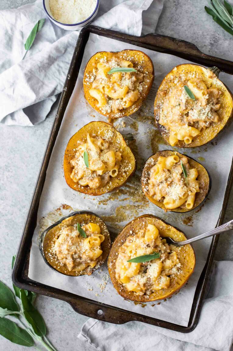 Mac and cheese stuffed acorn squash on a baking sheet.