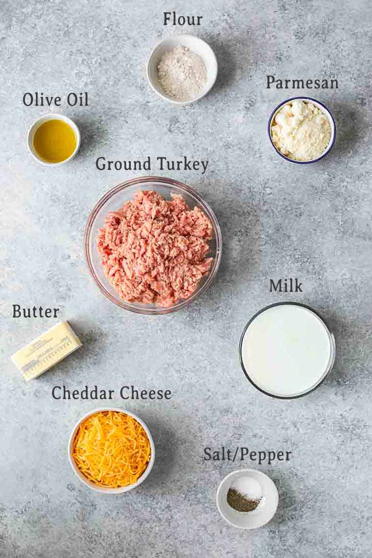 Ingredients for mac and cheese stuffed acorn squash on a grey background.