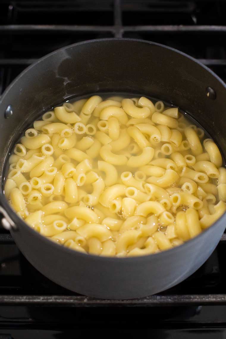 Elbow pasta cooking in a stockpot.