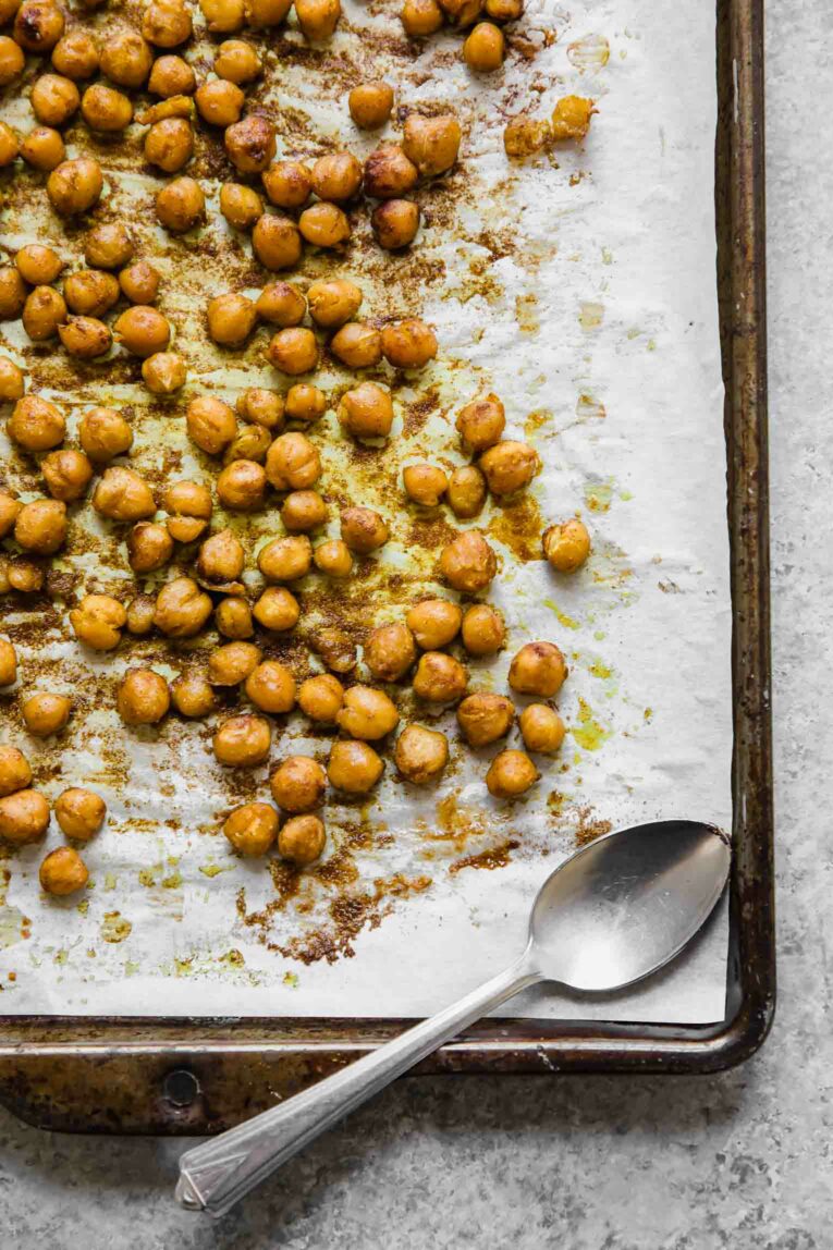 Roasted chickpeas on a baking sheet lined with parchment paper.
