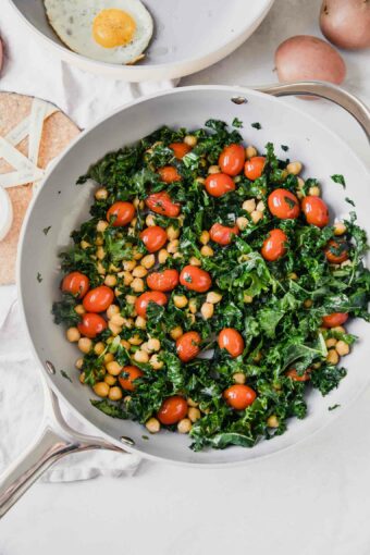 Top shot of non-stick non-toxic cookware with eggs, kale, tomatoes, and chickpeas.