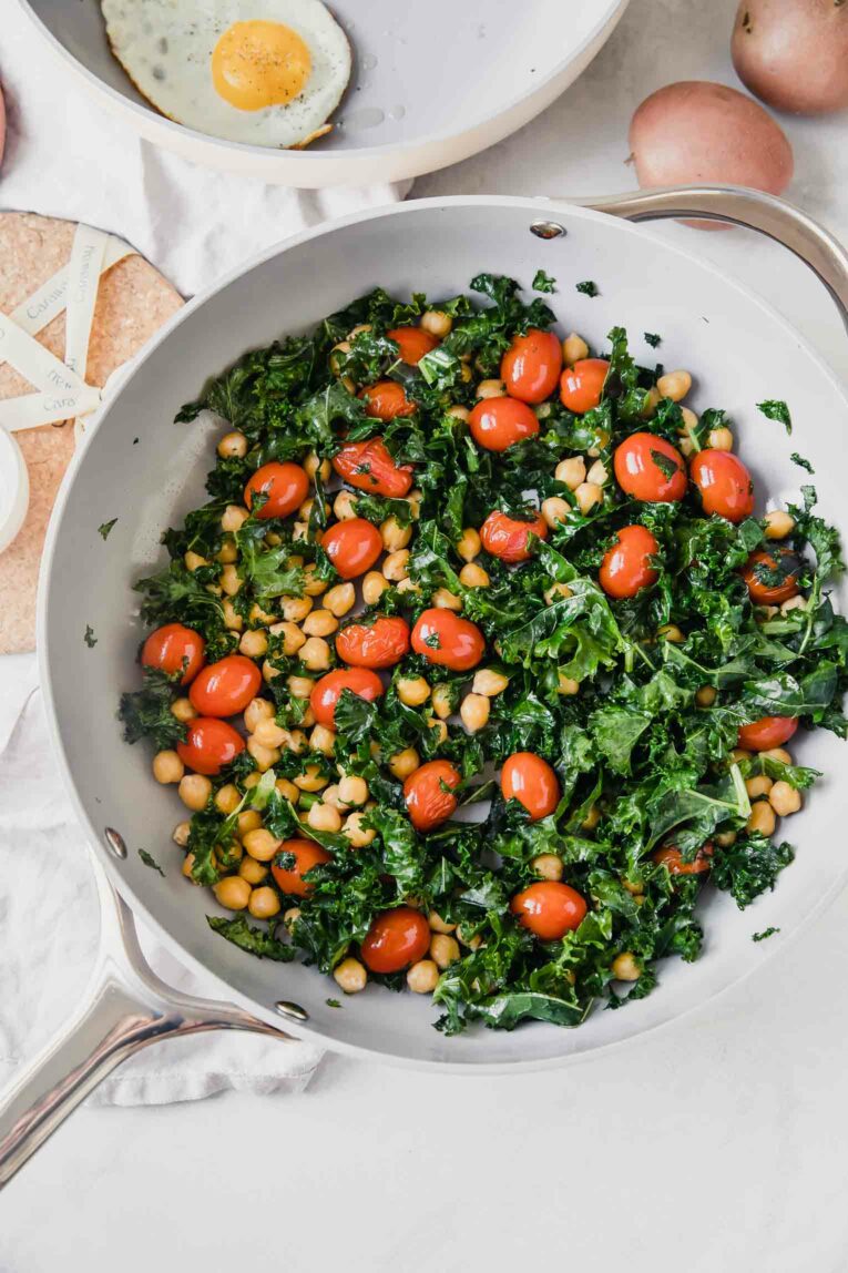 Top shot of non-stick non-toxic cookware with eggs, kale, tomatoes, and chickpeas.