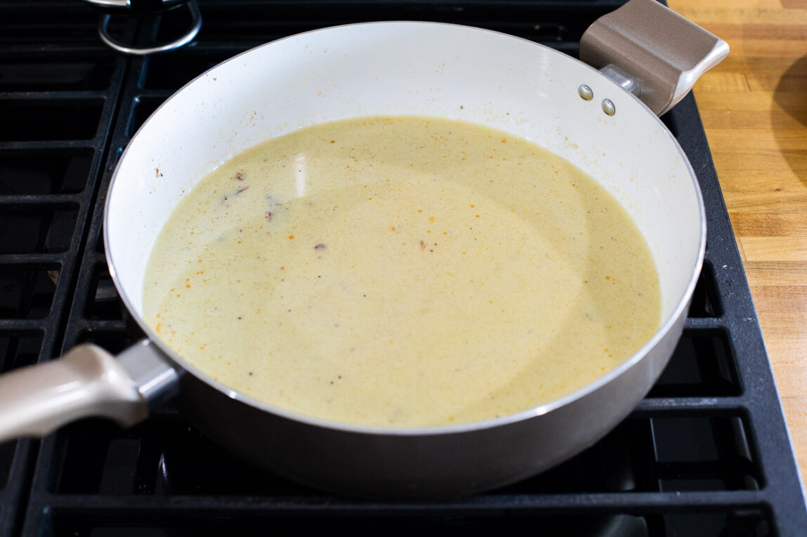 Creamy sauce in a white sauce pan.