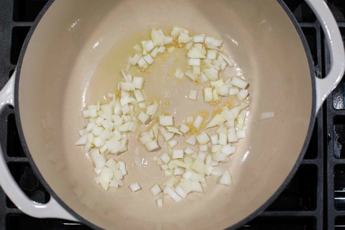Onions and garlic being cooked with oil.