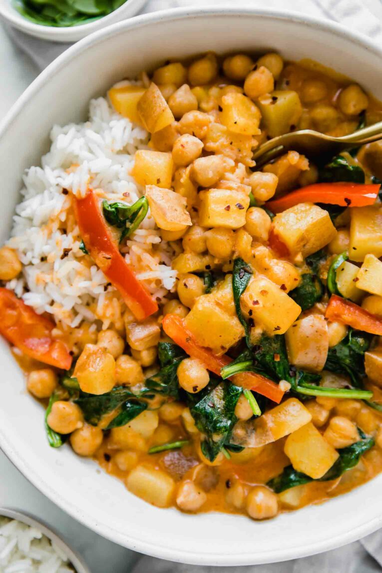 Close up of Easy Vegan Potato Curry with a spoon in a bowl.