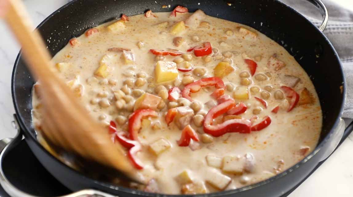 Potato curry being cooked in a skillet.