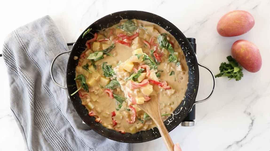 Spinach added to vegan potato curry.