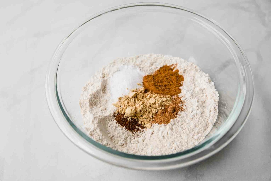 Dry ingredients for gingerbread loaf recipe in a glass bowl.