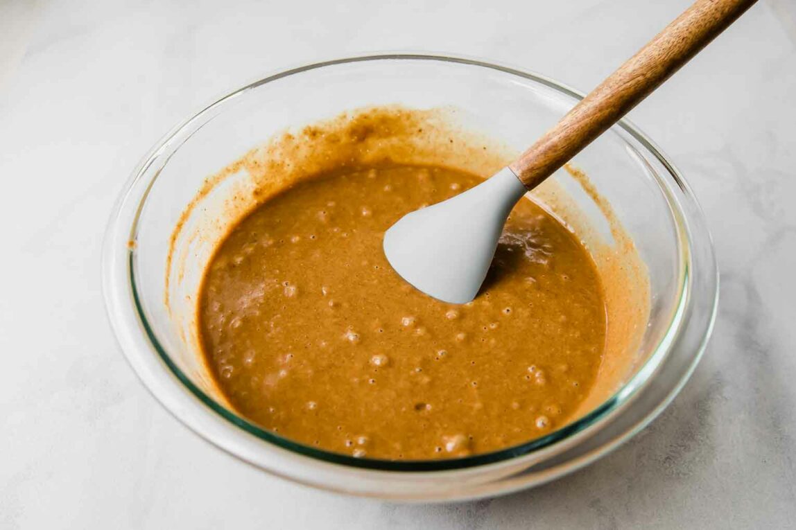 Gingerbread loaf batter being mixed in a glass bowl.