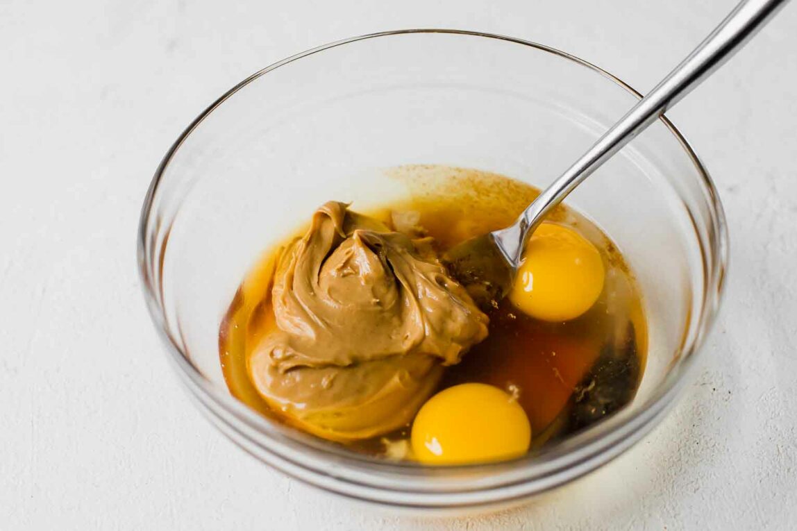 Liquid ingredients for protein cookies being mixed in a bowl.
