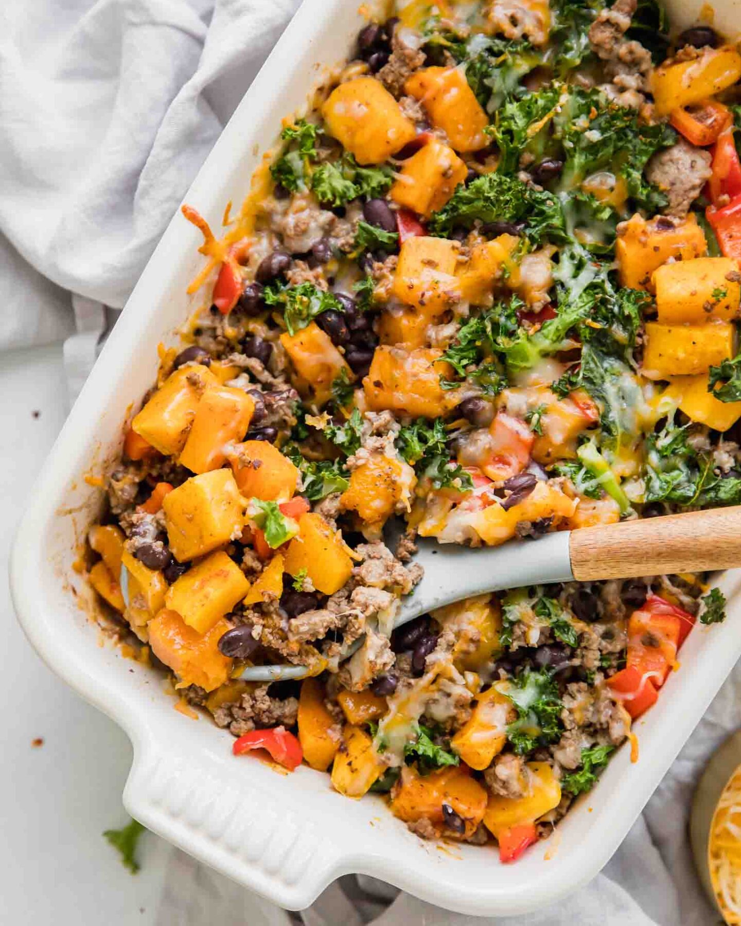 Spicy Southwest Butternut Squash Casserole with wooden spoon.