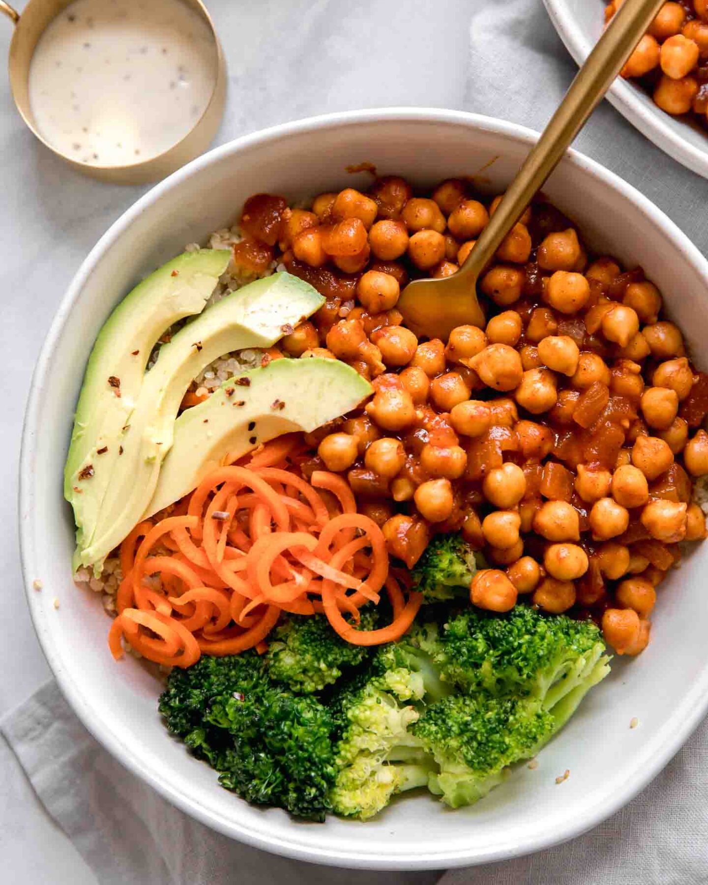 Close up of vegan buffalo chickpea bowls with a fork on a marble background.