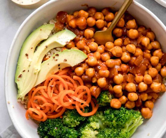Close up of vegan buffalo chickpea bowls with a fork on a marble background.