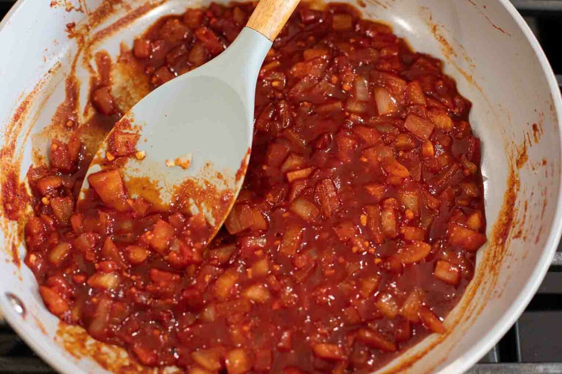 Buffalo sauce with onions and garlic in a pan.