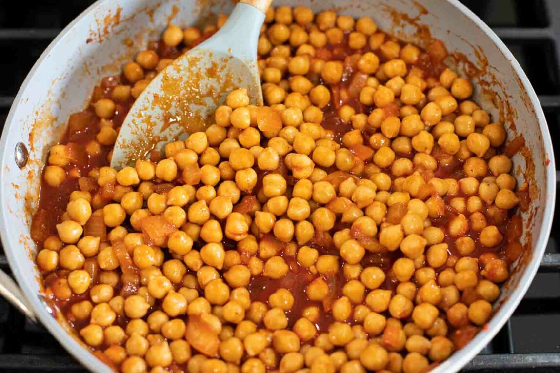 Chickpeas in buffalo sauce in a pan.