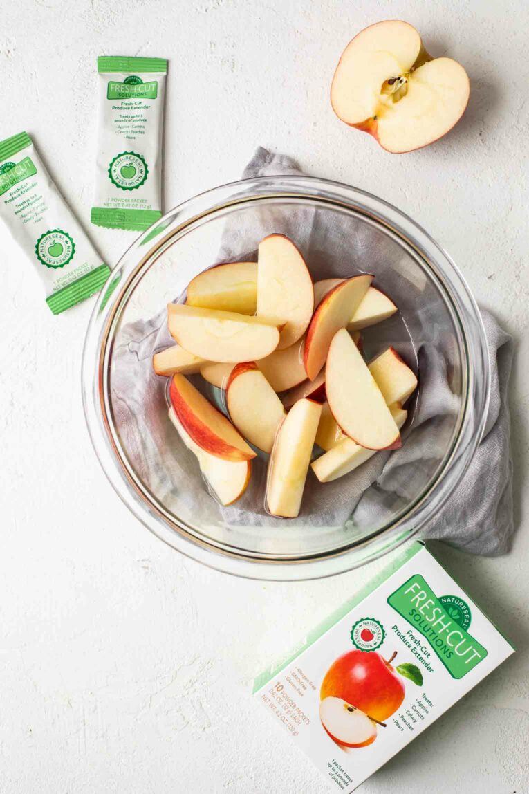 Apple slices being soaked in NatureSeal to keep produce fresh.