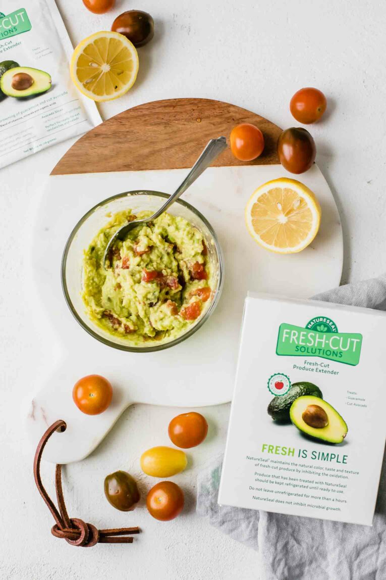 Guacamole, lemons, and tomatoes next to NatureSeal box.