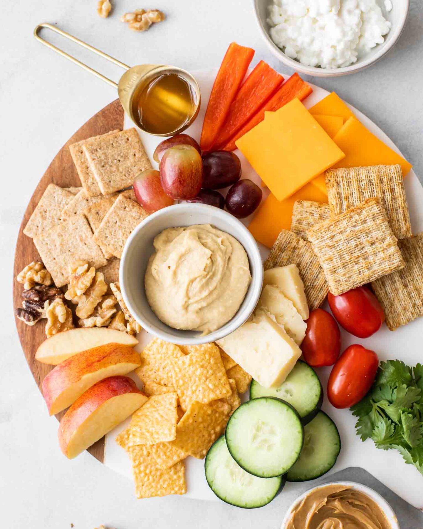 Better-for-you snack ideas on a white marble round cheeseboard.