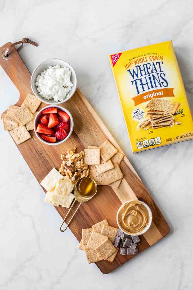 Cheese board next to wheat thins box.