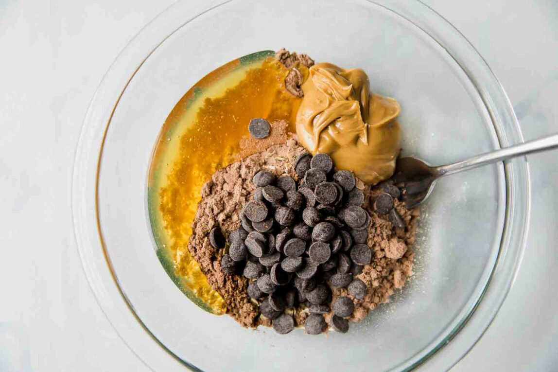Ingredients for protein balls being mixed in a bowl.