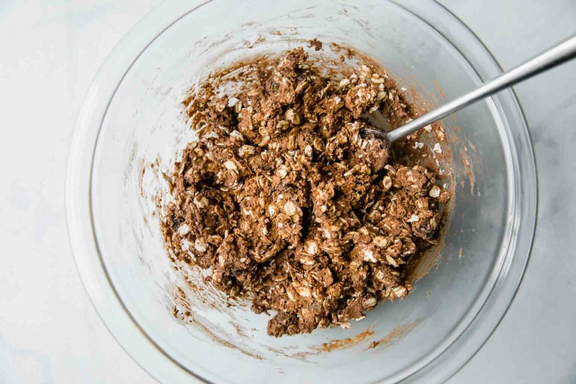 Ingredients for protein balls mixed thoroughly in a glass bowl.