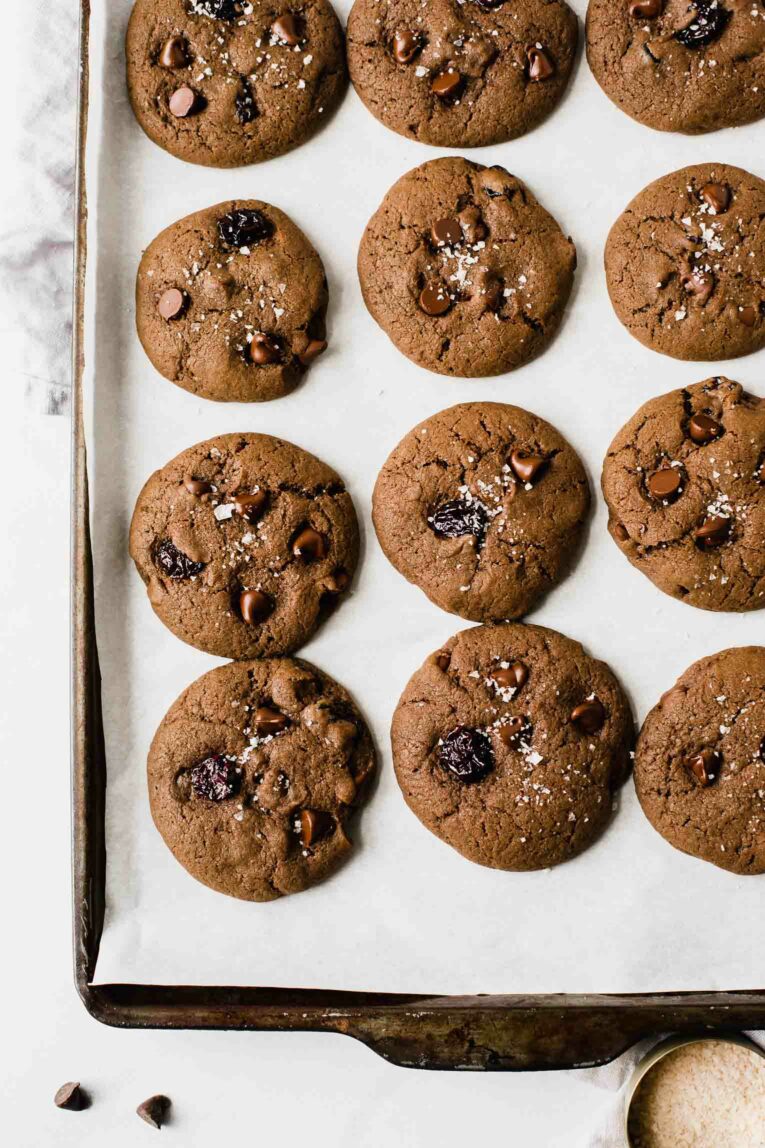 Top shot of freshly baked healthy chocolate cookies on parchment paper.