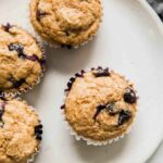 Top shot of toddler muffins with blueberries on a white plate.