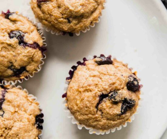 Top shot of toddler muffins with blueberries on a white plate.