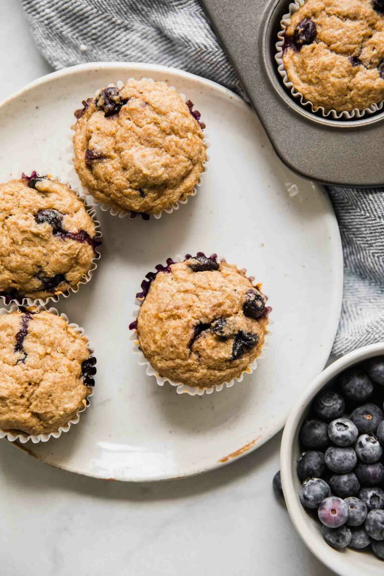 Several toddler blueberry muffins on a white plate.