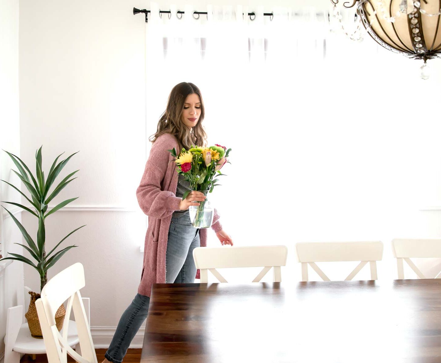 Woman adding flowers to her table to refresh home for spring.
